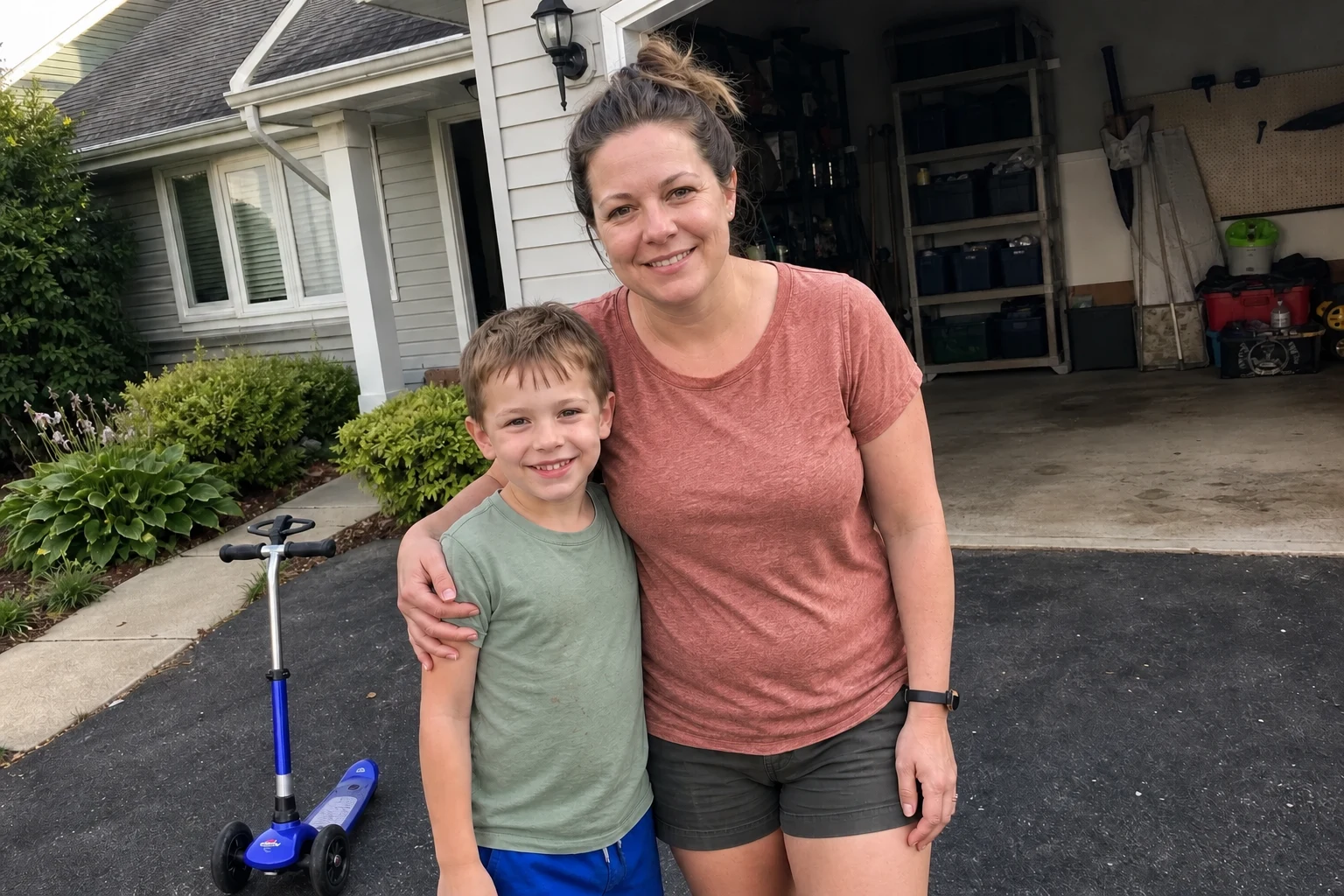 Mother and son together beside his scooter in their driveway